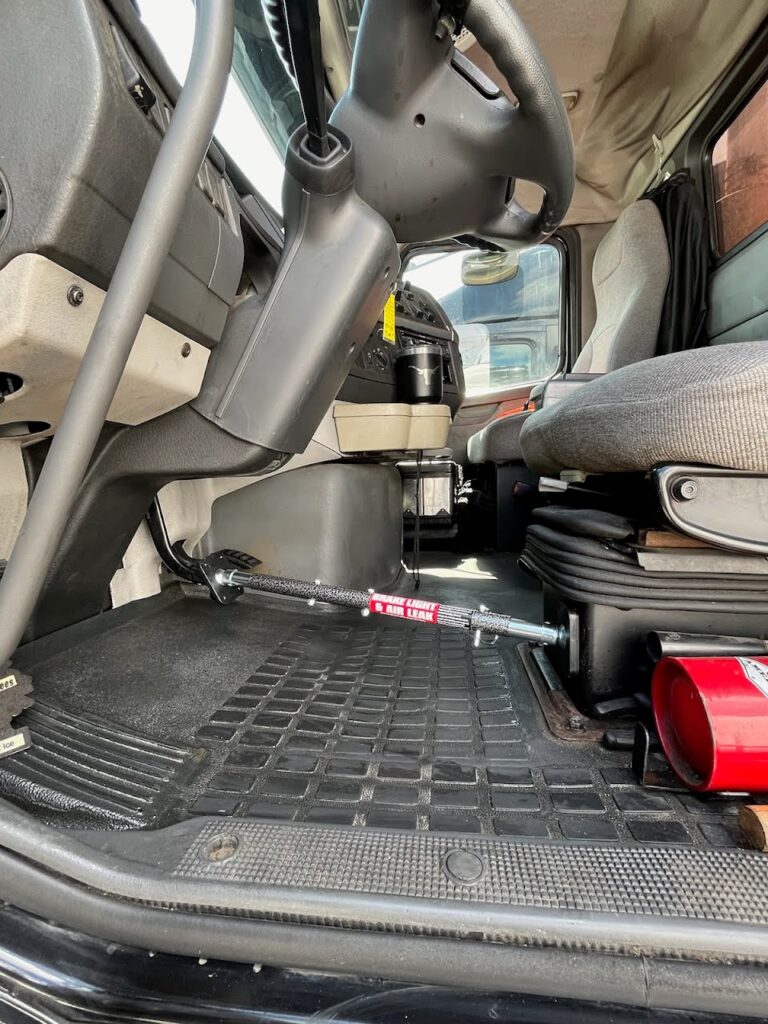 Brake Checker Pro deployed in the cab of a semi truck, holding the brake pedal down